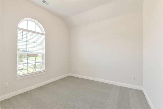 empty room with a wealth of natural light, visible vents, and carpet floors