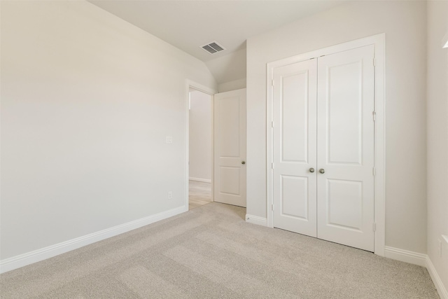 unfurnished bedroom with light colored carpet, baseboards, visible vents, and a closet
