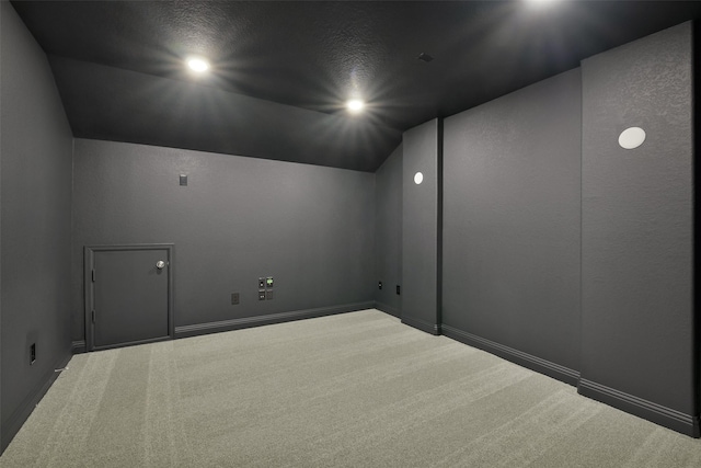 spare room featuring baseboards, lofted ceiling, and carpet
