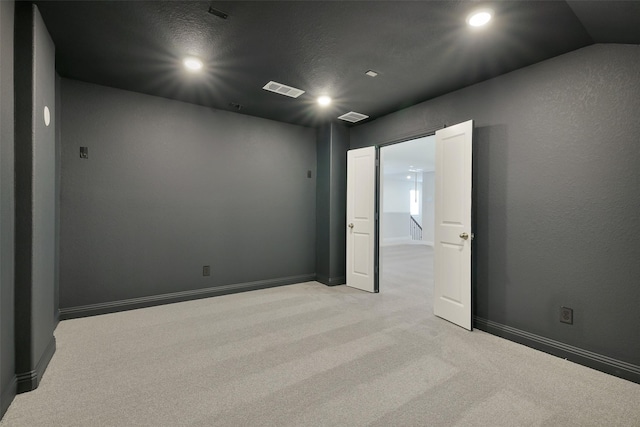 empty room with recessed lighting, visible vents, baseboards, and light carpet