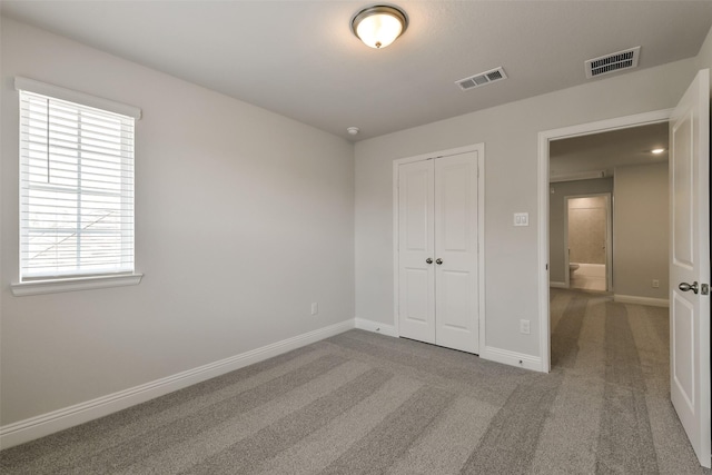 unfurnished bedroom with visible vents, a closet, and multiple windows