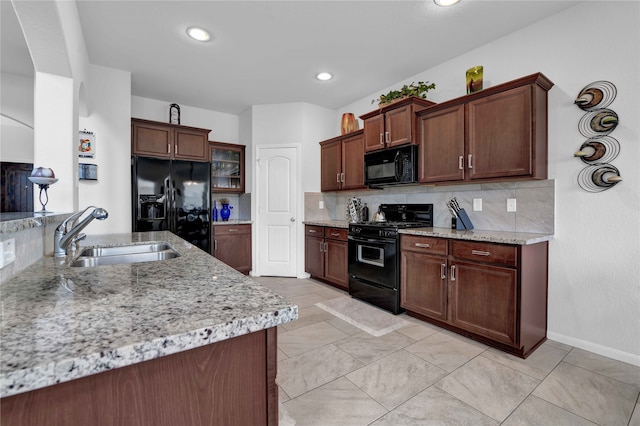 kitchen with backsplash, black appliances, sink, dark brown cabinets, and light stone counters