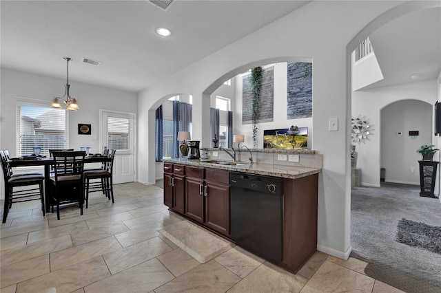 kitchen featuring light stone counters, dark brown cabinets, sink, pendant lighting, and dishwasher