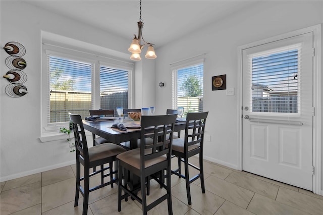 tiled dining area featuring an inviting chandelier