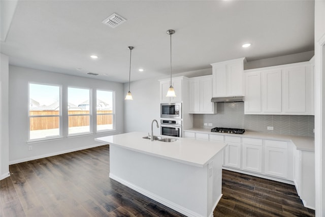 kitchen with white cabinets, a center island with sink, sink, and stainless steel appliances