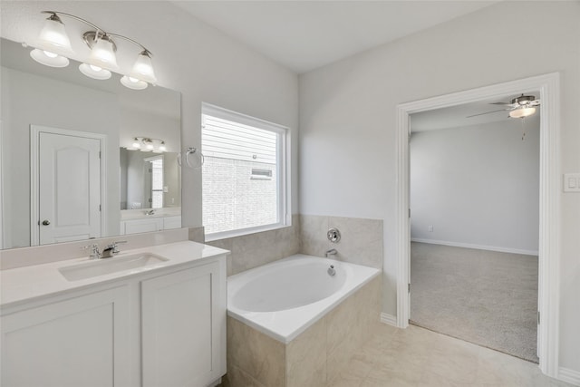 bathroom featuring tile patterned floors, vanity, ceiling fan, and tiled tub