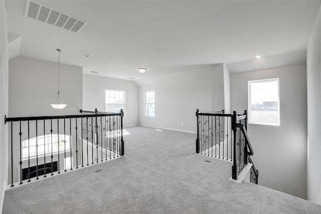 hallway with carpet flooring and lofted ceiling