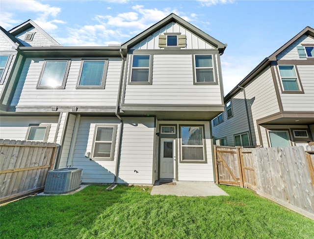 rear view of property with central AC unit, a patio, and a lawn