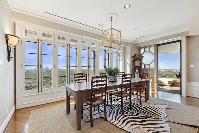 dining room with a chandelier, ornamental molding, a healthy amount of sunlight, and wood-type flooring