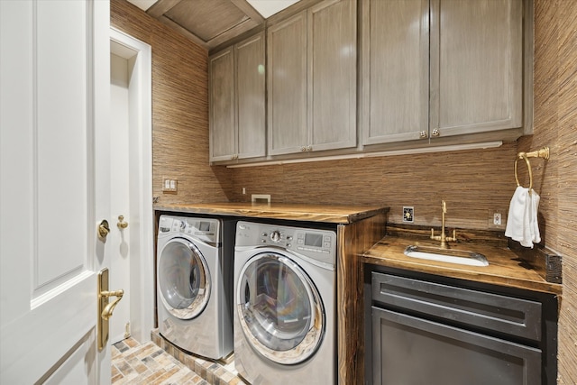 clothes washing area with cabinets, sink, and washing machine and clothes dryer