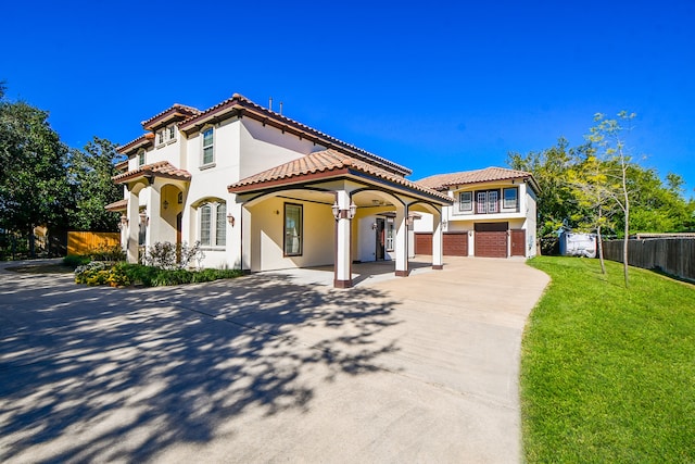 mediterranean / spanish home with a front yard and a garage