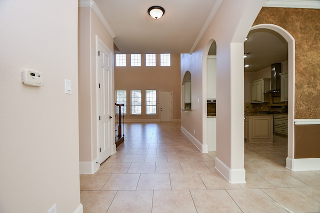 hall featuring light tile patterned floors and crown molding