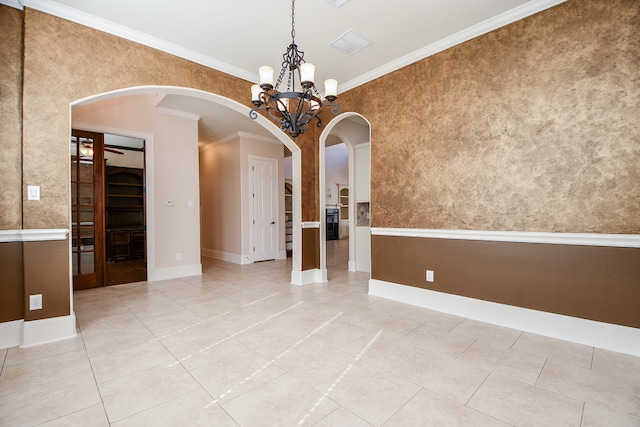 spare room with crown molding, light tile patterned flooring, and an inviting chandelier