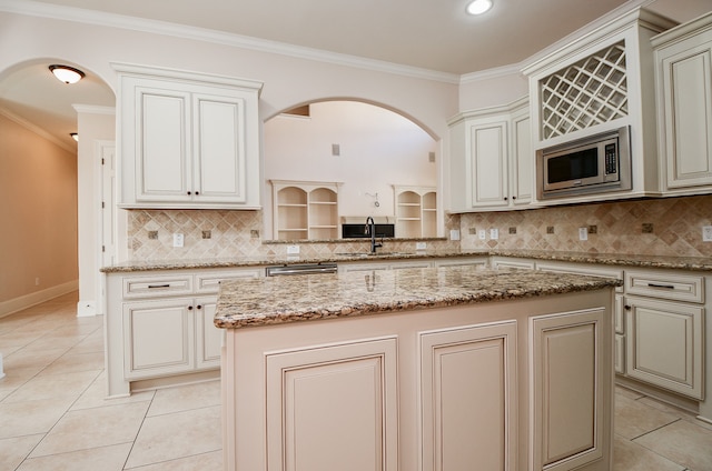 kitchen featuring backsplash, a kitchen island, ornamental molding, and appliances with stainless steel finishes