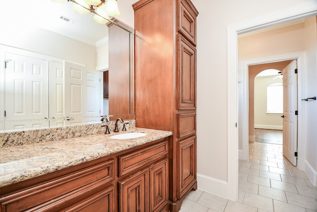 bathroom featuring tile patterned flooring, vanity, and crown molding