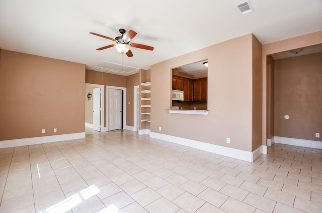 unfurnished living room featuring built in shelves, ceiling fan, and light tile patterned floors