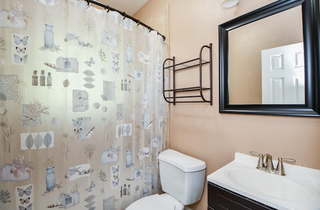 bathroom with a shower with shower curtain, vanity, and toilet