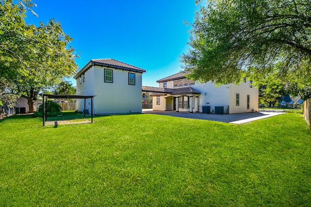 back of house with a lawn and a patio