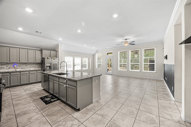 kitchen with sink, stainless steel appliances, gray cabinetry, and an island with sink