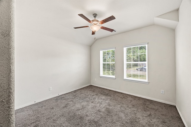 spare room with dark colored carpet, ceiling fan, and lofted ceiling