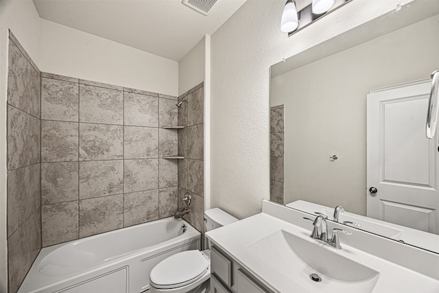 full bathroom featuring a textured ceiling, vanity, toilet, and tiled shower / bath