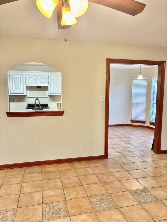 interior space featuring ceiling fan, sink, and light tile patterned floors