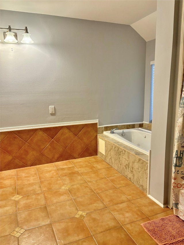 bathroom with tile patterned floors, lofted ceiling, and tiled bath