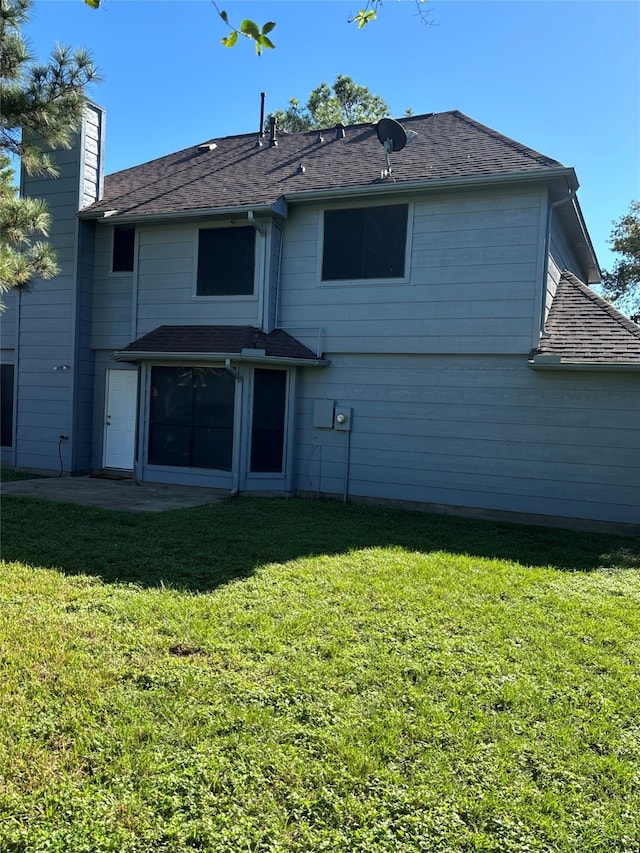 rear view of property with a lawn and a patio