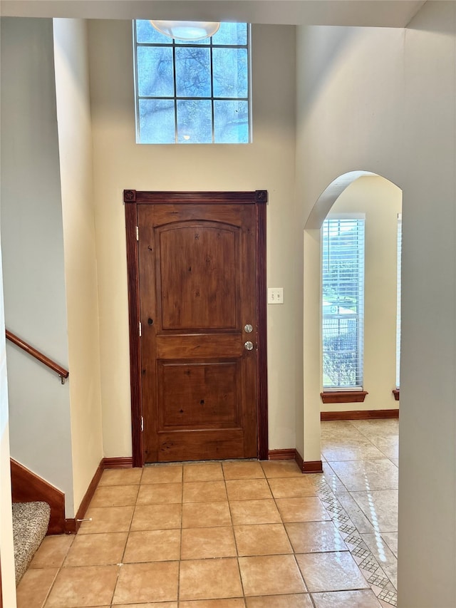 foyer with light tile patterned floors and a towering ceiling