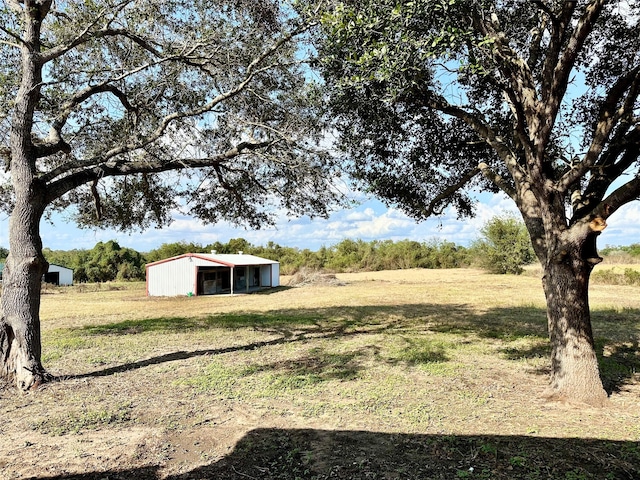 view of yard featuring a rural view and an outdoor structure