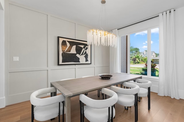 dining area featuring light hardwood / wood-style floors and an inviting chandelier