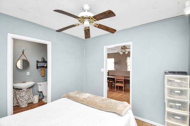 bedroom featuring hardwood / wood-style floors, a textured ceiling, ceiling fan, and sink