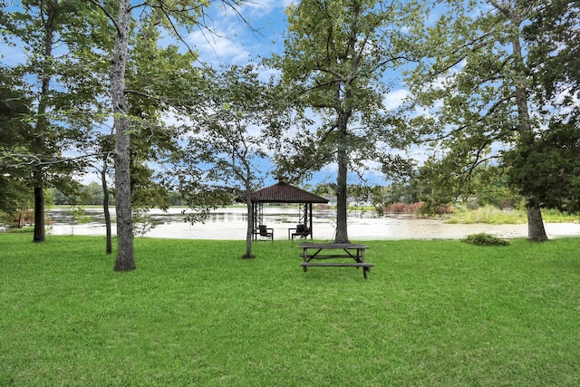 surrounding community with a gazebo, a yard, and a water view