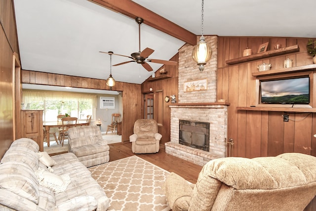 living room featuring vaulted ceiling with beams, wooden walls, wood-type flooring, and a brick fireplace