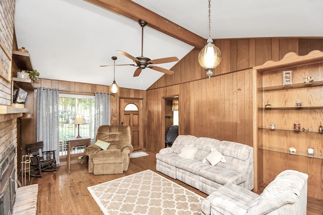 living room with ceiling fan, vaulted ceiling with beams, wood walls, wood-type flooring, and a fireplace