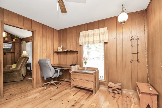 office with vaulted ceiling, light hardwood / wood-style flooring, ceiling fan, and wood walls