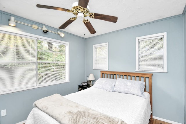 bedroom featuring hardwood / wood-style flooring, ceiling fan, and ornamental molding