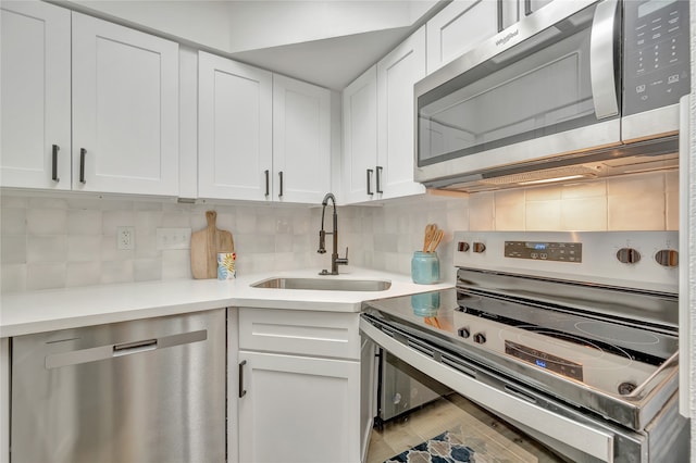 kitchen featuring backsplash, sink, white cabinets, and stainless steel appliances