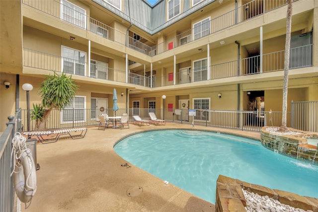 view of pool featuring pool water feature and a patio area