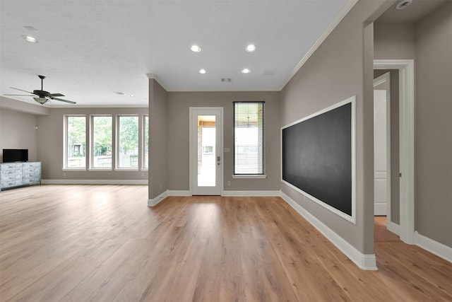 entrance foyer with ceiling fan, a wealth of natural light, ornamental molding, and light hardwood / wood-style flooring