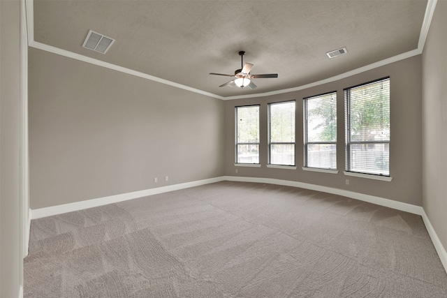 carpeted spare room featuring ceiling fan, a healthy amount of sunlight, crown molding, and a textured ceiling