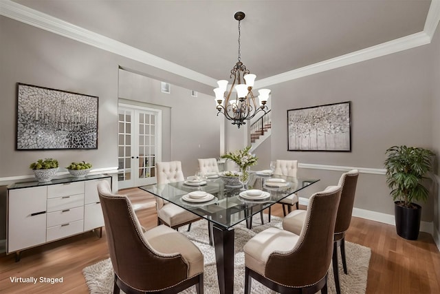 dining space featuring french doors, dark hardwood / wood-style floors, an inviting chandelier, and ornamental molding