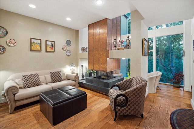 45 Briar Hollow Ln Unit 4, Houston, TX 77027 - living area with a tiled fireplace, light wood-style floors, and recessed lighting