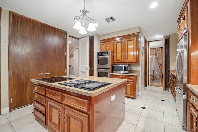 kitchen featuring hanging light fixtures, stainless steel appliances, an inviting chandelier, a kitchen island with sink, and light tile patterned floors