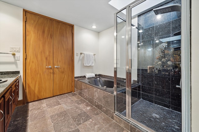 bathroom featuring vanity and independent shower and bath