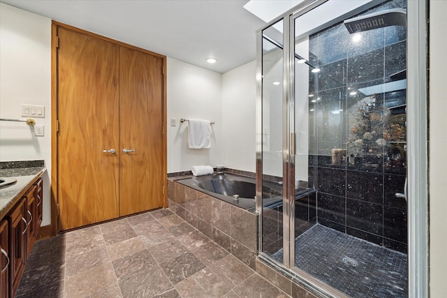 45 Briar Hollow Ln Unit 4, Houston, TX 77027 - bathroom with a bath, vanity, a stall shower, and recessed lighting