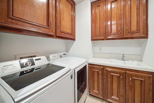 laundry area featuring cabinets, sink, and washing machine and clothes dryer