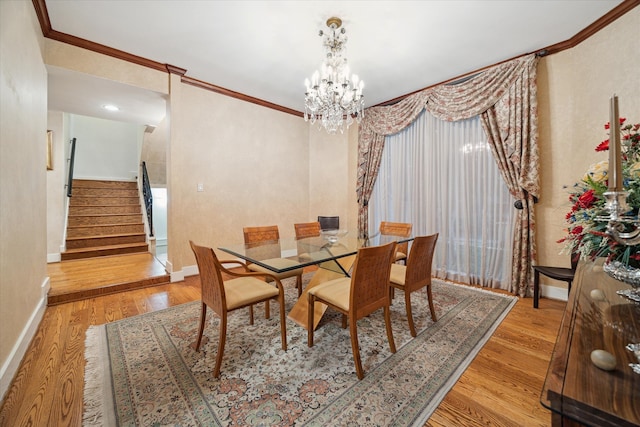 dining room featuring light hardwood / wood-style floors, ornamental molding, and an inviting chandelier