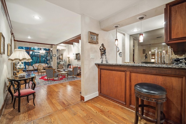 45 Briar Hollow Ln Unit 4, Houston, TX 77027 - bar area featuring light wood-type flooring and decorative light fixtures