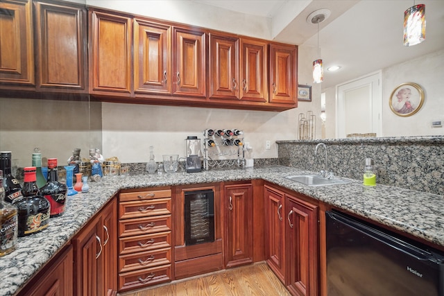 kitchen with dishwasher, sink, light stone countertops, and light hardwood / wood-style floors